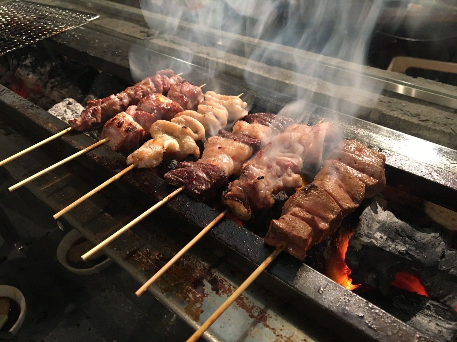 炭火の煙の中で焼き上がる、マニトンの朝びきやきとん
